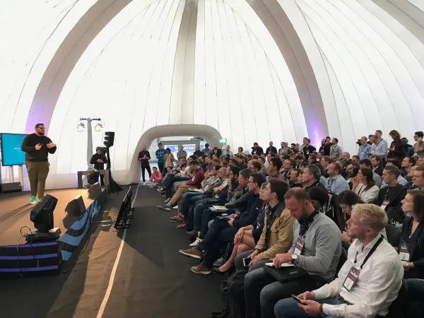 Live during SaaStock Europe 2018 — wide side-on view of the Growth Stage dome interior, the tunnel entrance at right framing the doorway and the full seated audience filling the floor