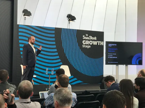Live during SaaStock Europe 2018 — Thomas Smale, founder of FE International, opening the Growth Stage with the 'Chairperson's Welcome' slide visible on the side screen, inside the inflatable Growth Stage dome at RDS Simmonscourt, Dublin