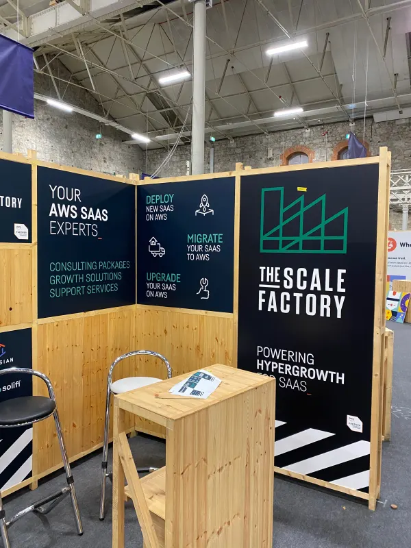 Before doors at SaaStock Europe 2022 — the AWS sponsor booth at SaaStock Dublin paired with The Scale Factory 'Powering Hypergrowth For SaaS' panel, 'Your AWS SaaS Experts' messaging on display