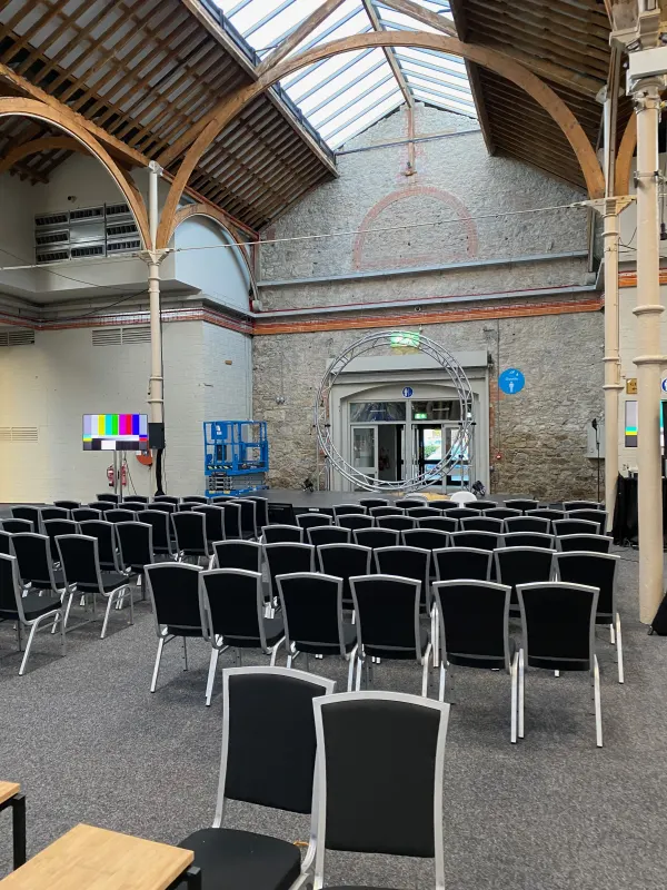 Before doors at SaaStock Europe 2022 — the Growth Stage hall at the Dublin venue empty, with a large circular ring screen at the back and rows of chairs facing it under the timber-arched roof