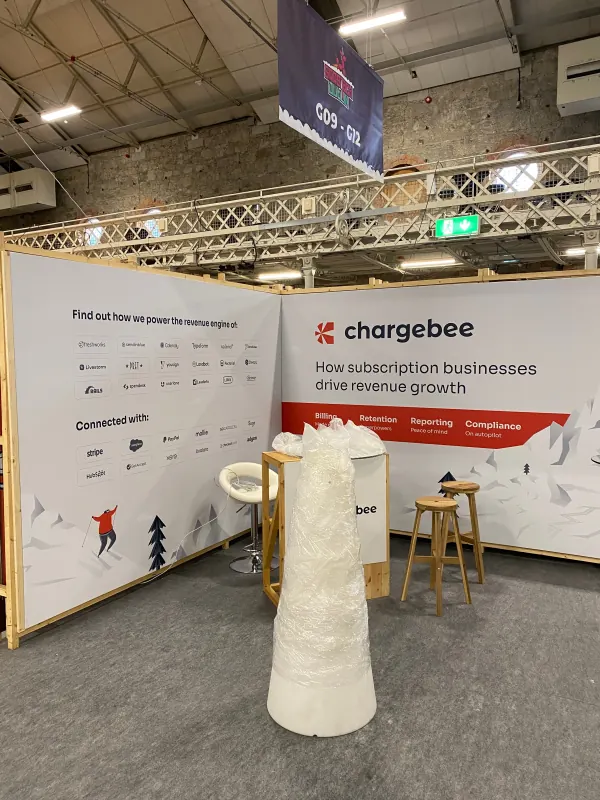 Before doors at SaaStock Europe 2023 — Chargebee sponsor booth with 'How subscription businesses drive revenue growth' messaging, integrations wall showing Stripe, PayPal and Salesforce