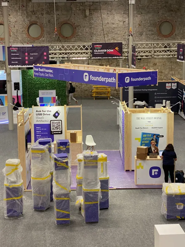 Before doors at SaaStock Europe 2023 — overhead view of the Founderpath sponsor booth with wrapped pallets in the foreground waiting to be unpacked, Dublin
