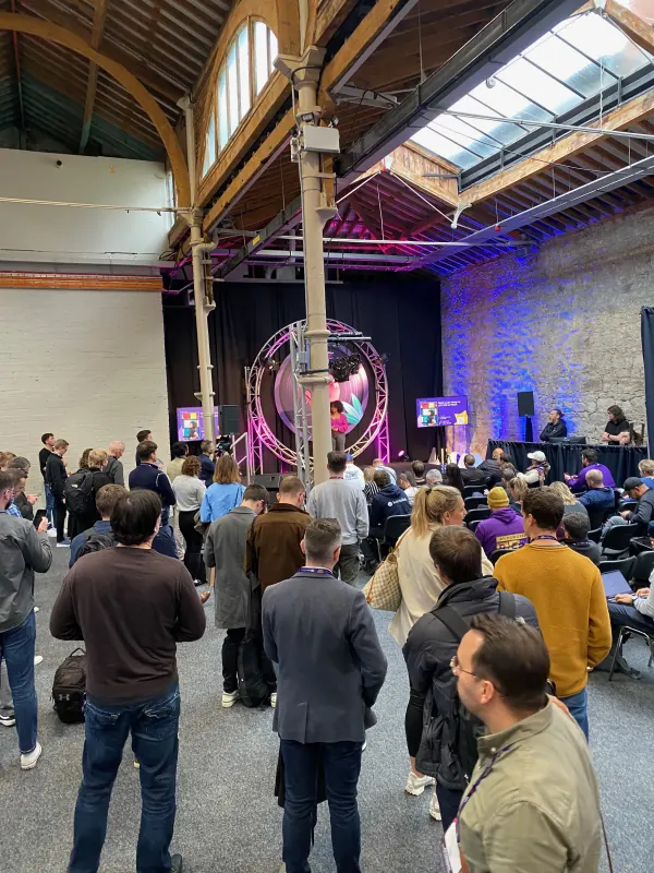 Live during SaaStock Europe 2023 — Bootstrap Stage at RDS Simmonscourt, Dublin, with a packed standing-room crowd watching speakers in front of an LED ring and SaaStock branding