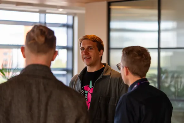 Live at SaaStock Europe 2023 Startup Day, Zendesk Dublin — three founders in conversation, the centre one in a Carrot-illustration tee with rust-red corduroy collar visible