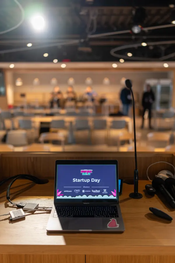 Before SaaStock Europe 2023 Startup Day at Zendesk Dublin — a MacBook on the Zendesk-branded host desk showing the 'Startup Day' slide with AppSumo, CMS Hub, Intercom, SaaStock and Zendesk sponsor logos