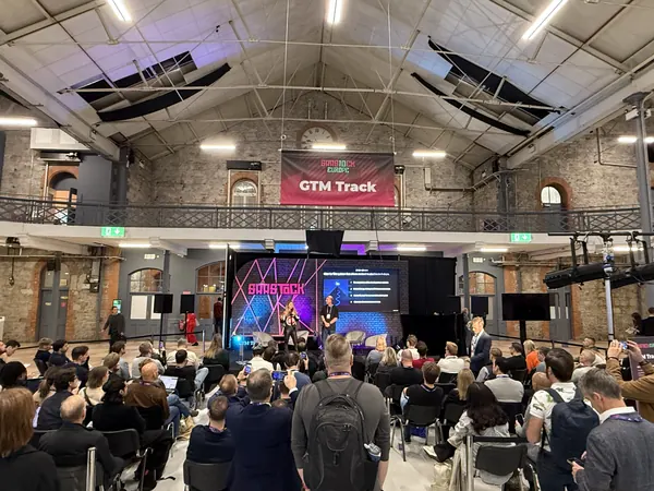 Live during SaaStock Europe 2025 — Reditus booth with a founder demoing 'Grow your MRR without upfront costs' and a 'Grow your B2B SaaS Faster' LinkedIn lead-magnet on the counter