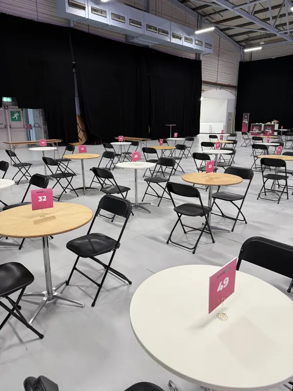 Behind the scenes at SaaStock Europe 2025 — empty 1:1 meeting tables (numbered 32, 49, …) waiting for opening morning at the RDS in Dublin