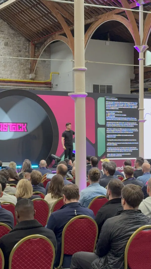 Live during SaaStock Europe 2025 — Founderpath founder presenting on the SaaStock arch-backed mainstage with a packed seated audience facing him