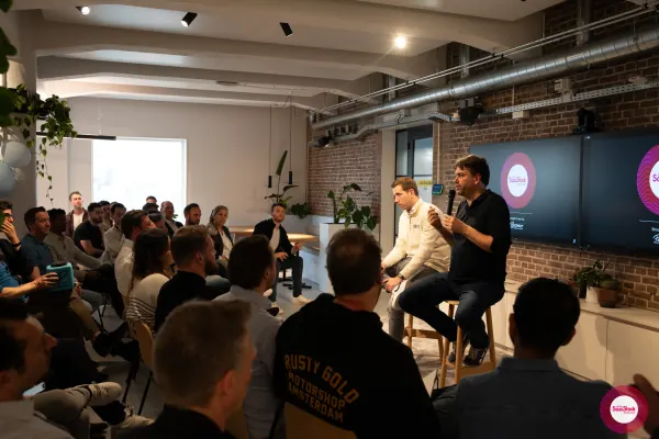 Live at SaaStock Local Amsterdam Q2 2024 — wide angle of the seated audience listening to the panel, with the SaaStock Local Amsterdam × Personio screens at the front