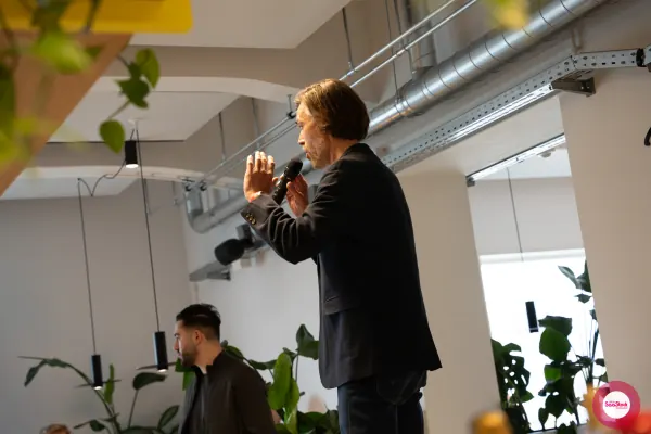 Live at SaaStock Local Amsterdam Q2 2024 — Ferdinand Goetzen gesturing with both hands while holding a microphone, mid-talk