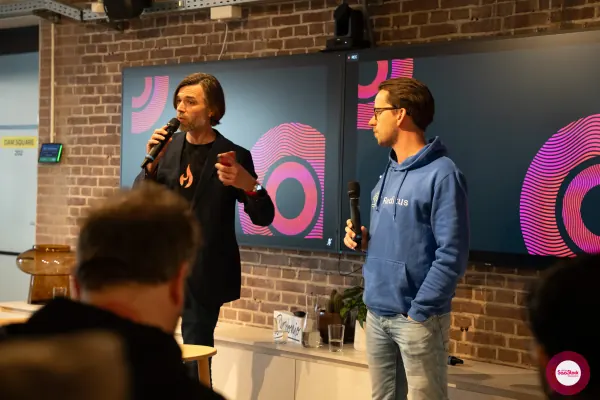 Live at SaaStock Local Amsterdam Q2 2024 — Ferdinand Goetzen (dark blazer with flame logo) and Joran Hofman (blue Reditus hoodie) standing side by side with microphones