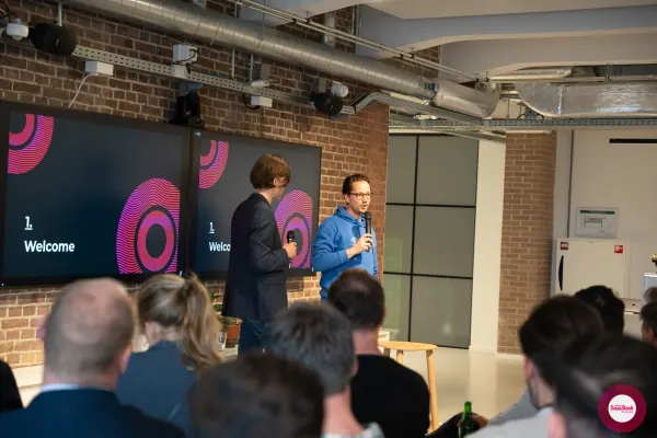 Live at SaaStock Local Amsterdam Q2 2024 — wider angle of Joran Hofman and Ferdinand Goetzen on stage with the SaaStock Local Amsterdam screens behind