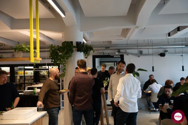 Founders mingling around the buffet at Personio's Amsterdam office before the SaaStock Local Amsterdam Q2 2024 talks