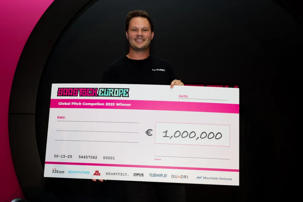 Limelight Founder David Walsh at SaaStock Europe holding giant €1M cheque.